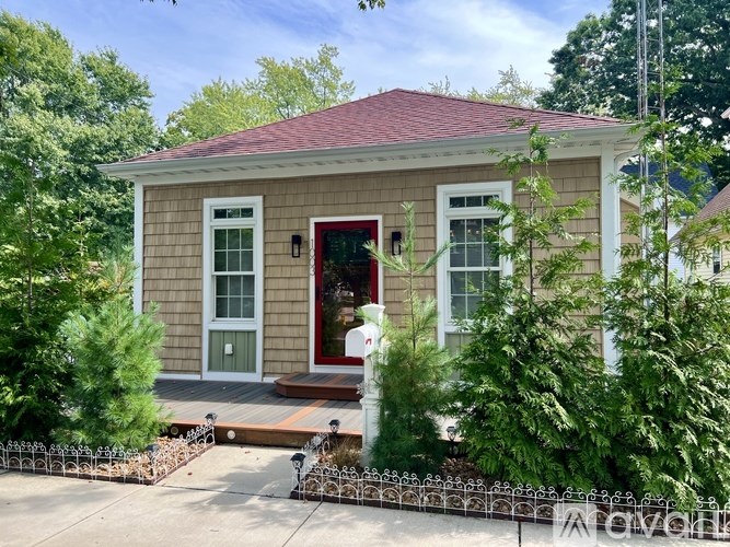 A small house with a red door and a red roof.