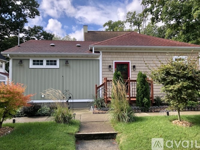 A house with a red door and a red railing on the porch.