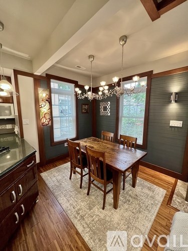 A dining room with a wooden table and chairs.