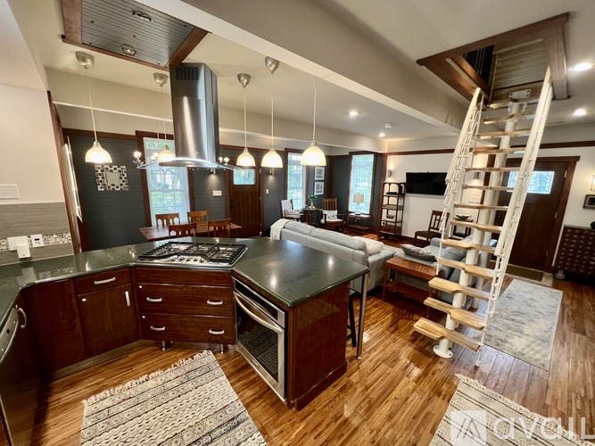 A modern kitchen with a large island and a staircase.