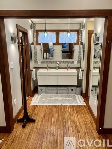 A bathroom with a wooden floor and a white sink.