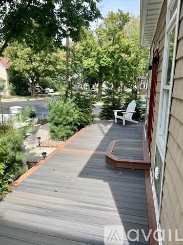 A wooden deck with a white chair and a brown border.