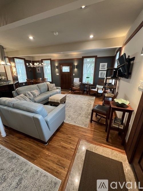 A living room with a grey sofa and a wooden floor.