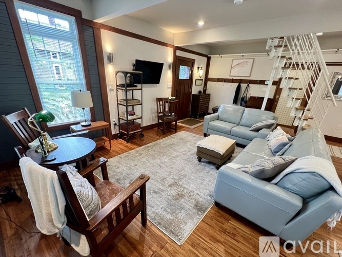 A living room with a grey couch and a wooden chair.