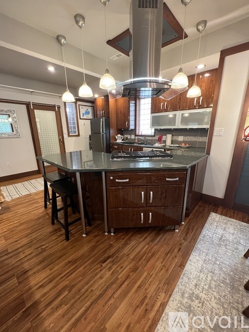 A modern kitchen with wooden floors and a large island.