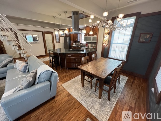A living room with a grey couch and a wooden dining table.