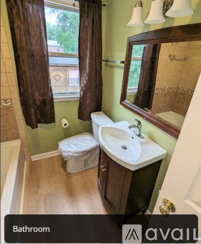 A bathroom with a toilet, sink, and mirror.