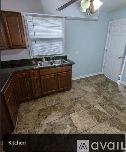 A kitchen with wooden cabinets and a tiled floor.