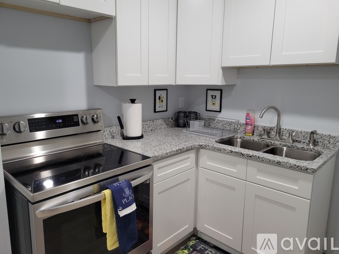 A kitchen with white cabinets and a granite countertop.