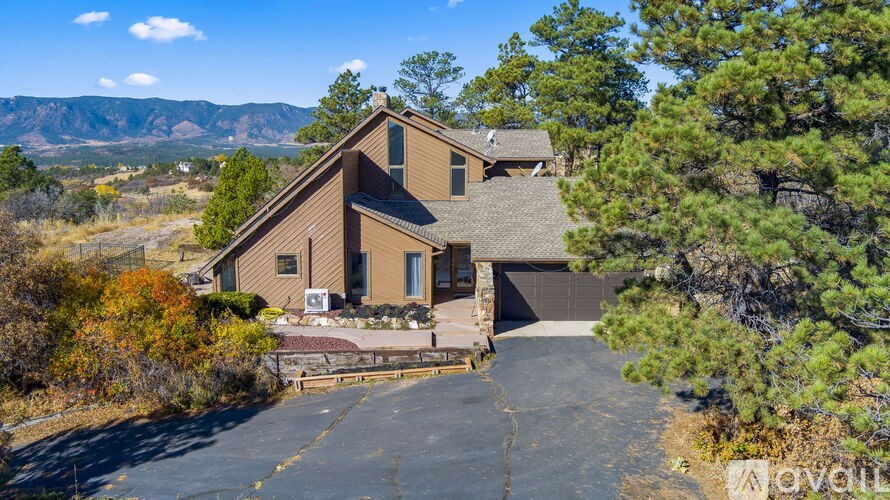 A house with a brown roof and a driveway in front of it.