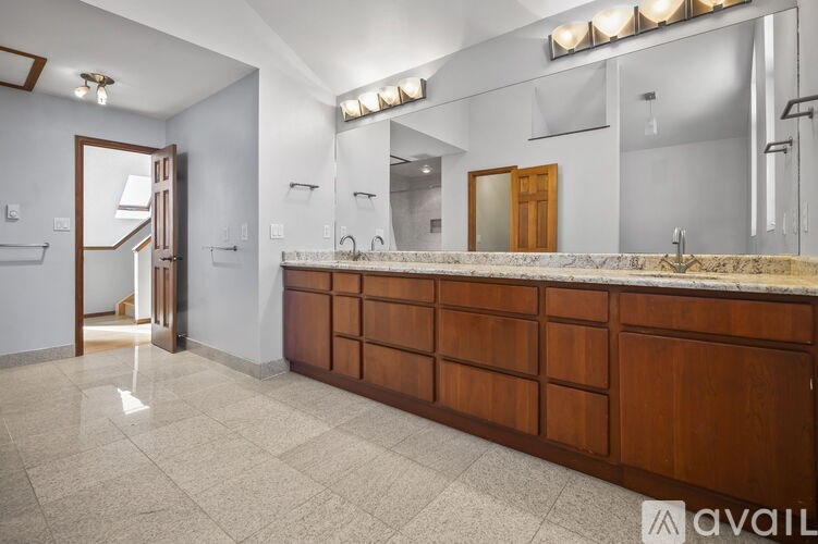 A bathroom with a marble countertop and a large mirror.