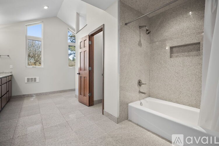 A bathroom with a tub, shower, and a window.