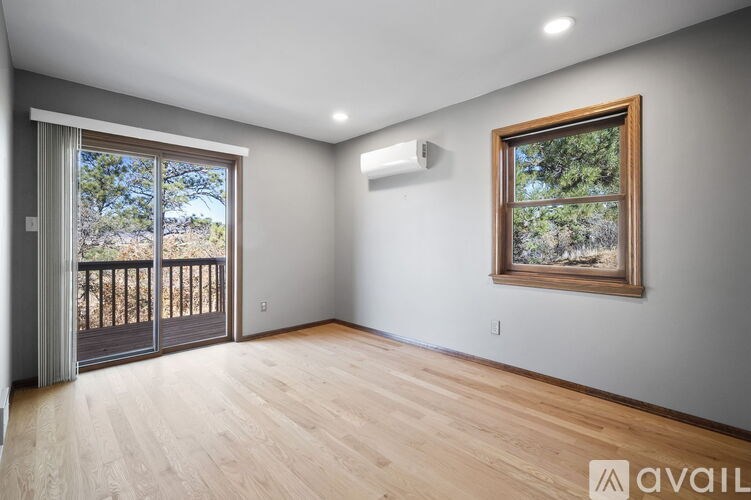 A room with wooden floors and a window with a painting on it.