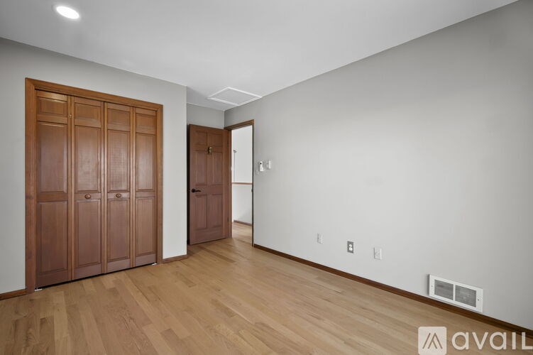 A room with wooden floors and two brown doors.