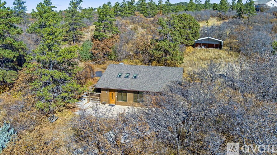 A house with a brown roof is surrounded by trees.