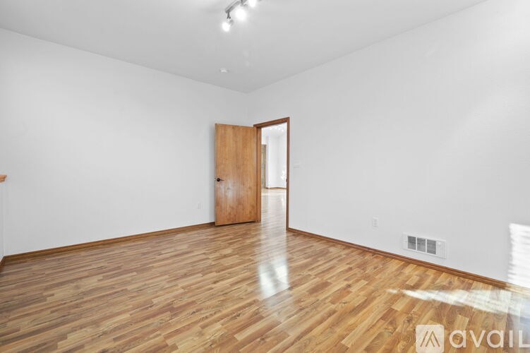 A room with wooden flooring and a door.
