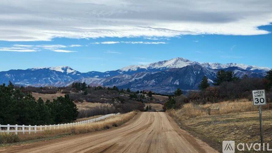 A road with a speed limit of 30 leading to a mountain range.