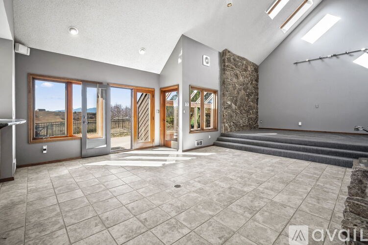 A spacious room with a stone wall and a row of windows.