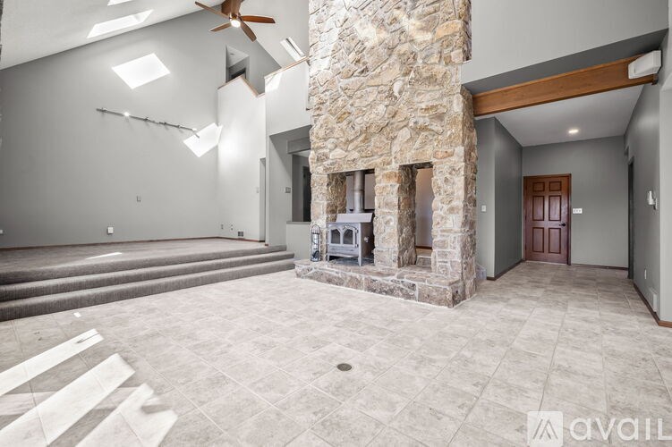 A stone fireplace is built into the wall of this spacious living room.