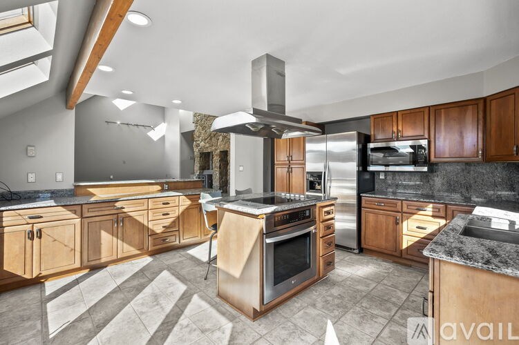 A modern kitchen with wooden cabinets and a marble countertop.