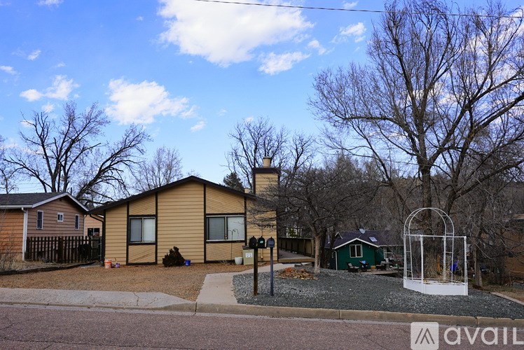 A house with a driveway and a tree in front of it.