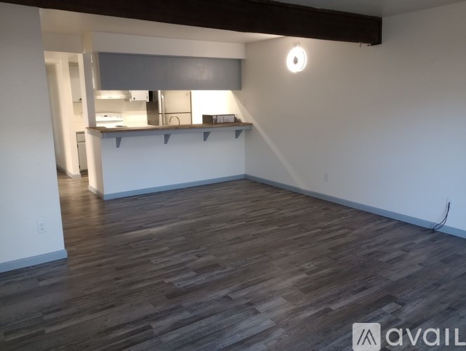 A room with wooden flooring and a white wall.