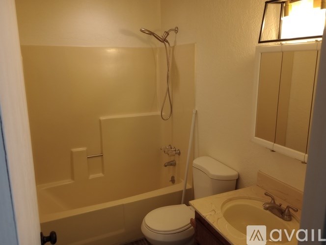 A bathroom with a toilet, sink, and bathtub.