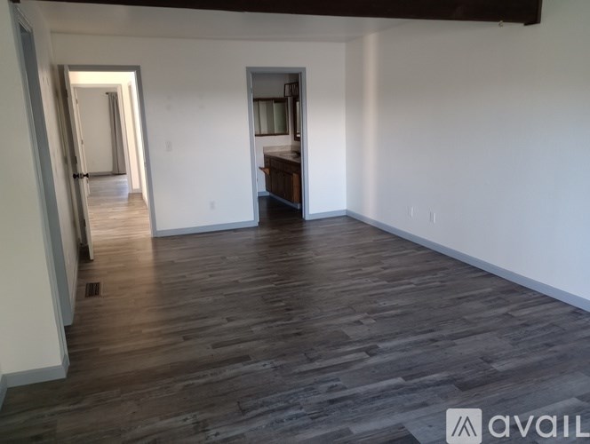 A room with wooden flooring and white walls.
