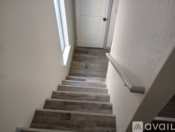 A staircase with wooden steps and a metal handrail.
