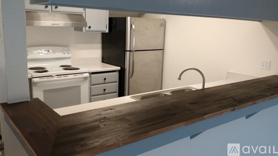 A kitchen with a white stove and a white refrigerator.