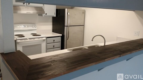 A kitchen with a white stove and a white refrigerator.