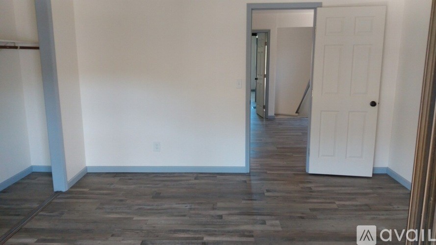 A room with wooden floors and a white door.