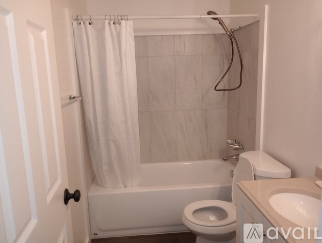 A bathroom with a white tub, toilet, and sink.