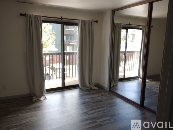 A room with a balcony and sliding glass doors.