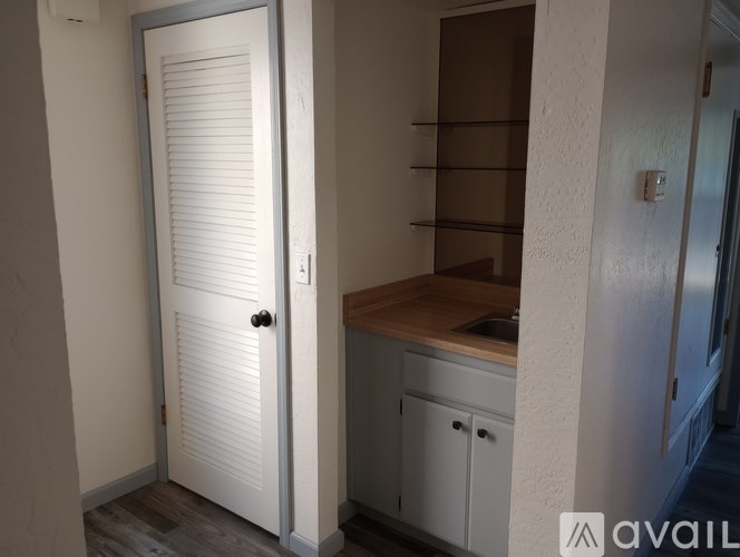 A white door with a shelf above it in a room.