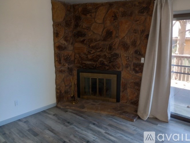 A room with a stone wall and a fireplace.