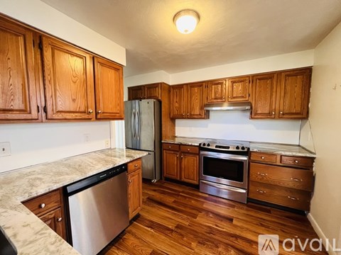 A kitchen with wooden cabinets and stainless steel appliances.