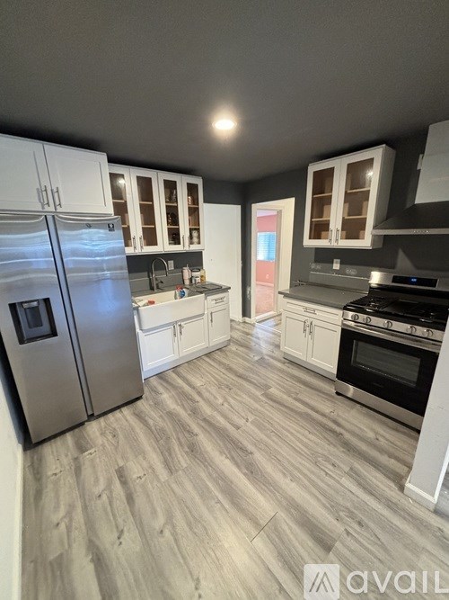 A modern kitchen with a refrigerator, oven, and cabinets.