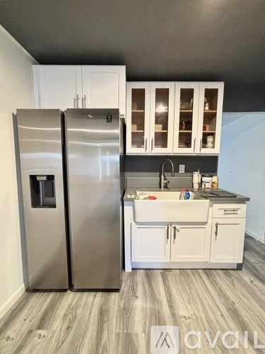 A kitchen with a refrigerator and cabinets.