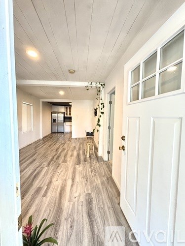 A long hallway with white doors and a wooden floor.
