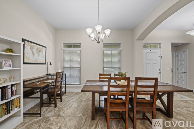 A dining room with a wooden table and chairs.