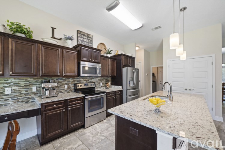 A kitchen with brown cabinets and a granite countertop.