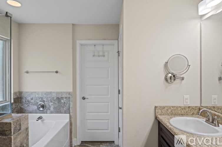 A bathroom with a white tub and sink.