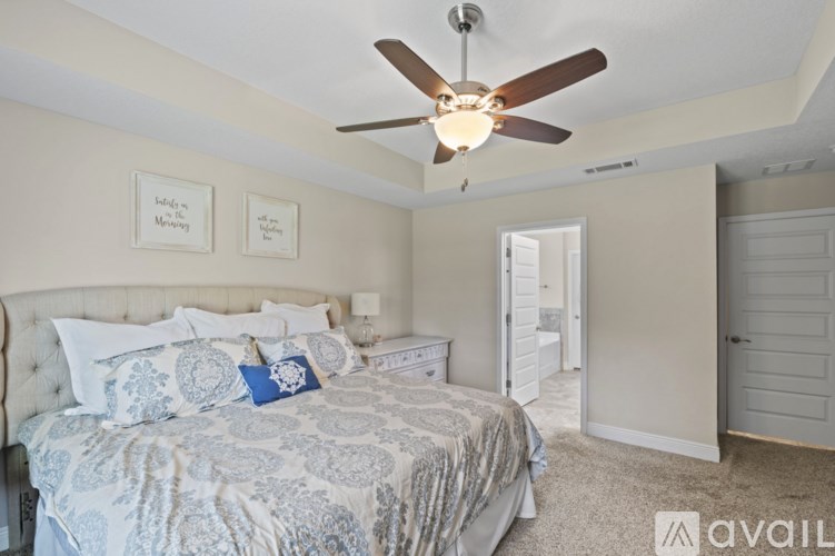 A bedroom with a large bed and a ceiling fan.