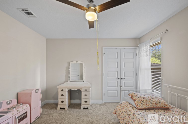 A room with a pink dresser and a white vanity table.