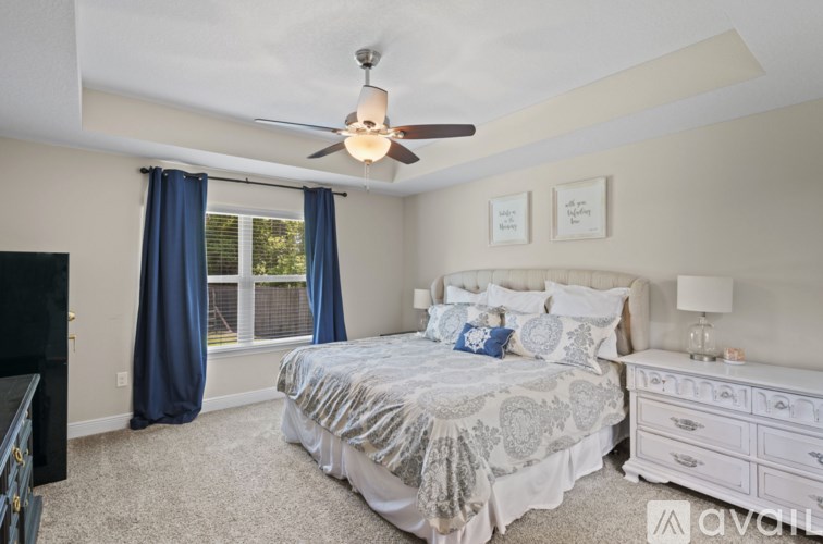 A bedroom with a large bed and a ceiling fan.