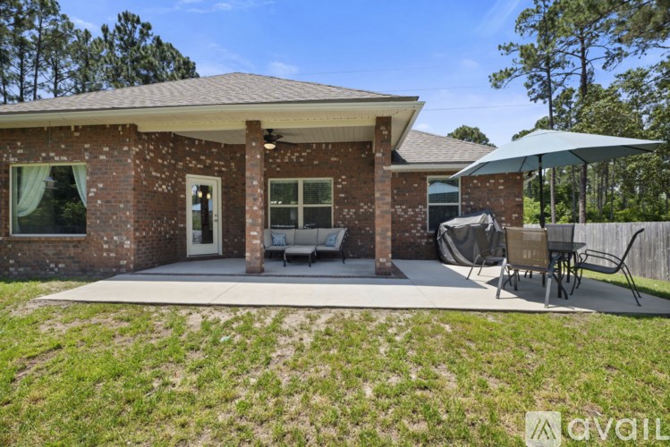 A house with a covered patio and a white umbrella.