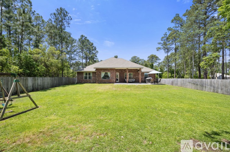 A house with a yard and a swing set.