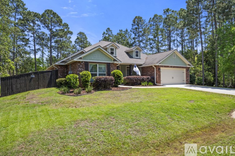 A house with a fence and greenery in front.