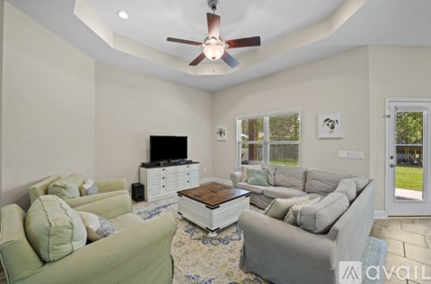 A living room with a green couch and a flat screen TV.